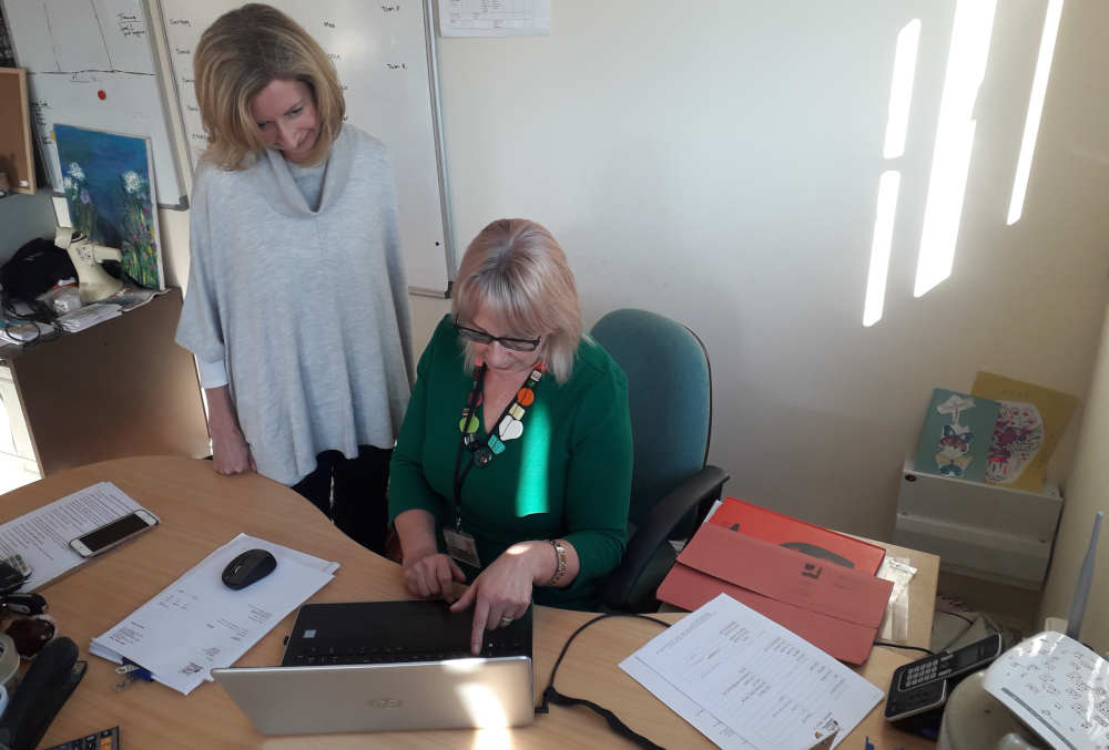 Dee working at her desk