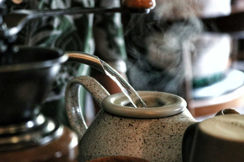 kettle pouring water into teapot